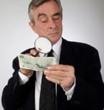 man with money and magnifying glass
