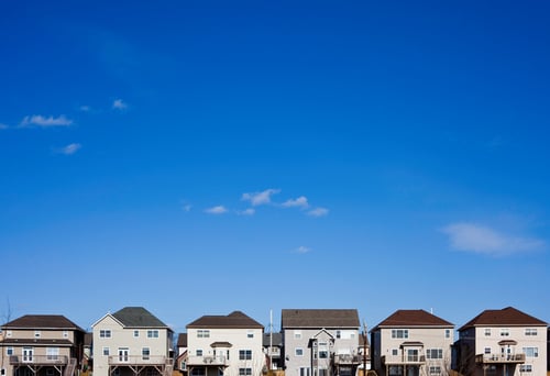 Row of suburb houses against bright blue sky