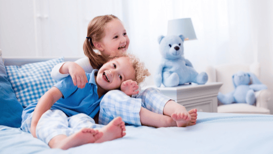 Two-laughing-children-on-a-bed