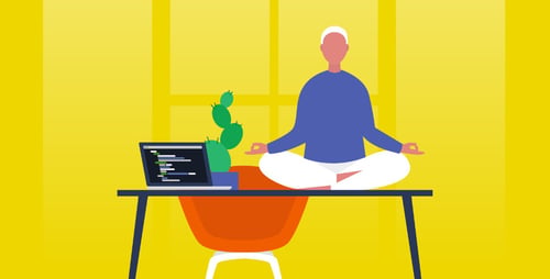 Person sits on desk doing meditation yoga next to their open laptop