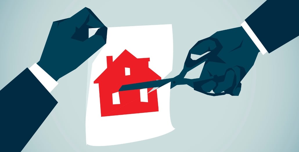 two-hands-cutting-up-an-image-of-home